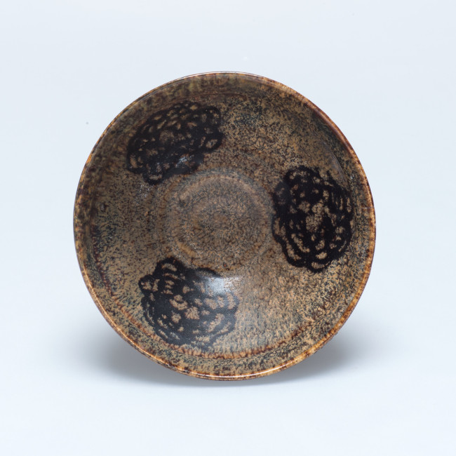 10. Stoneware tea bowl, the black motifs on the inside of the bowl were created by placing papercuts in the glaze that burned away during firing. Made in Ji’an, China, 960-1279, diameter 12.3 cm, Groninger Museum, 1935.0130