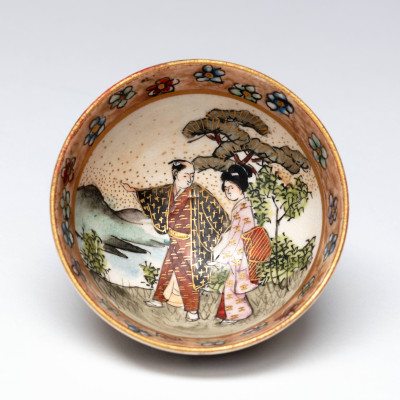 Sake cup with decoration of couple in a landscape, Kinkōzan Sōbei VII 七代錦光山宗兵衛 (1868–1927), Kyoto, Japan, 1880-1920, h. 2.5 x diam. 5 cm, stoneware with overglaze enamels and gilding, Groninger Museum (on loan from Anders Foundation), 2019.1226.
